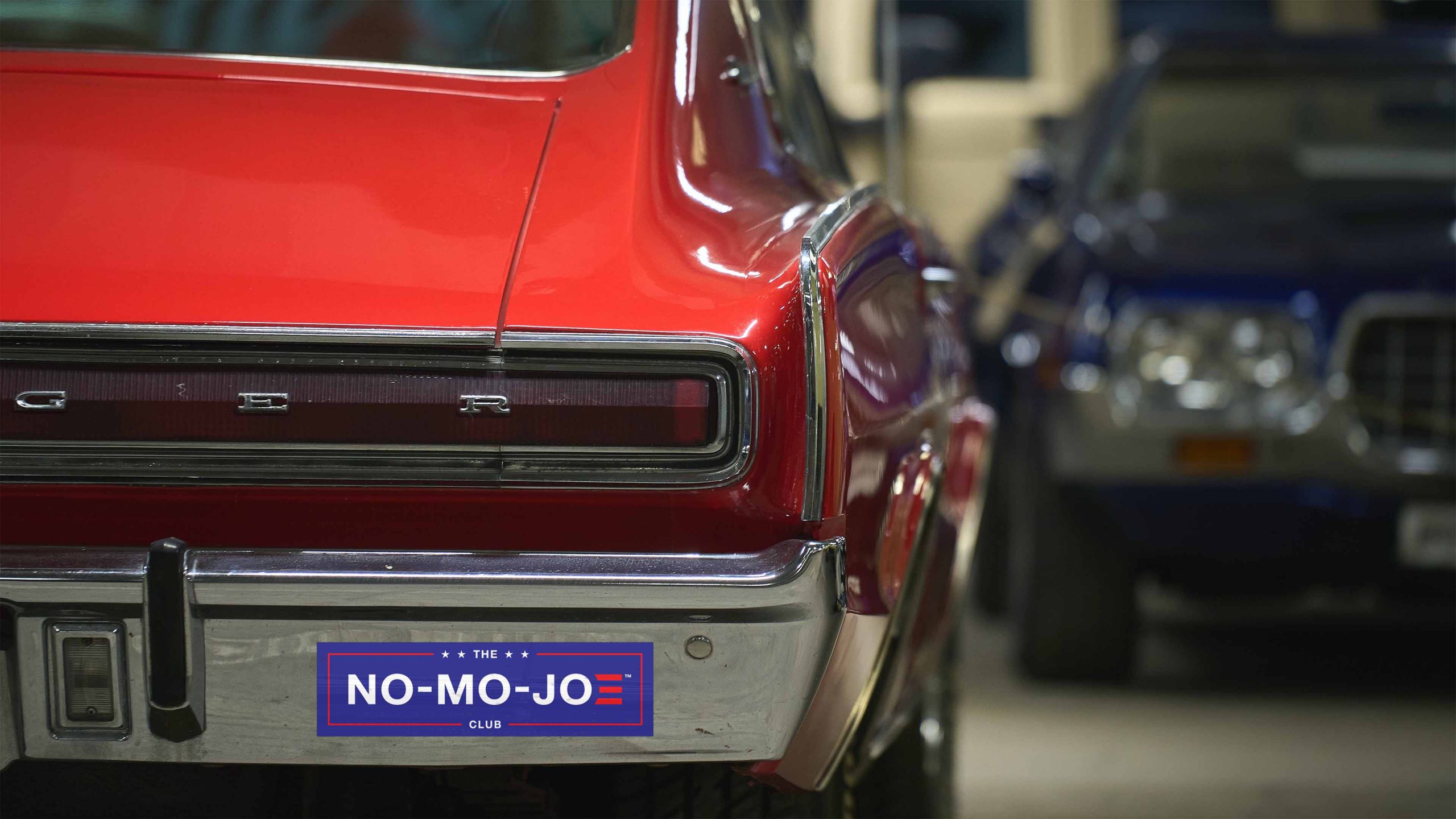 The No-Mo-Joe Club™ bumper sticker on vintage red car parked in garage