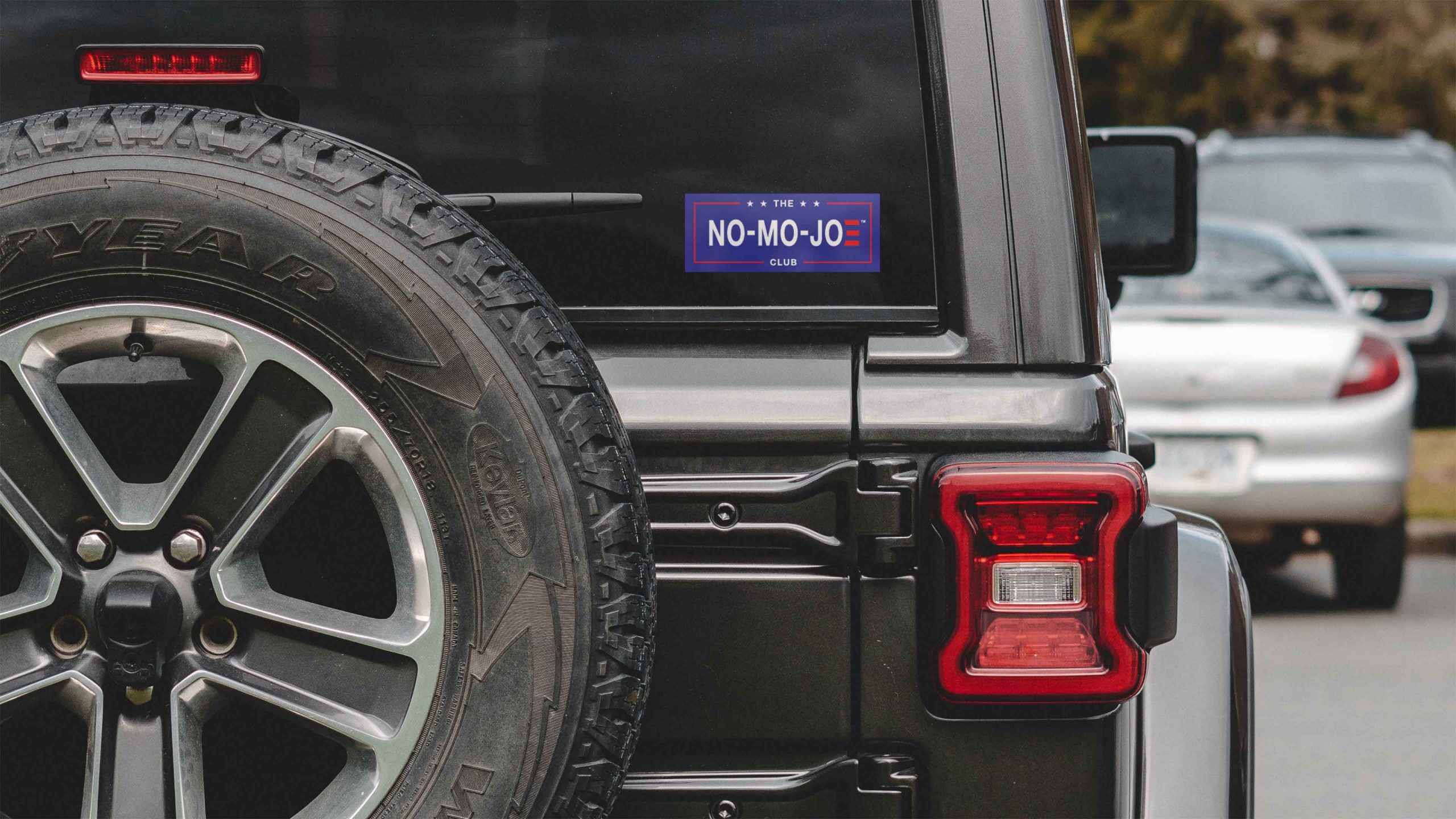 The No-Mo-Joe Club™ window cling on back window of black jeep in parking lot.